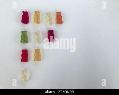 gummy bears lie on a white matte background. gummy bears are arranged by color. bright multicolored candy in the shape of a flag. handmade dessert. de Stock Photo