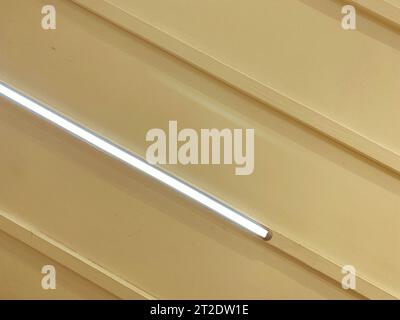 plastic white ceiling in the building. tiles made of artificial soft material for covering walls and ceilings. in the ceiling, a white lamp creates a Stock Photo