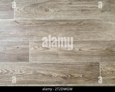 The surface texture of rubber artificial brown linoleum with a design for wood planks with knots. The background. Stock Photo