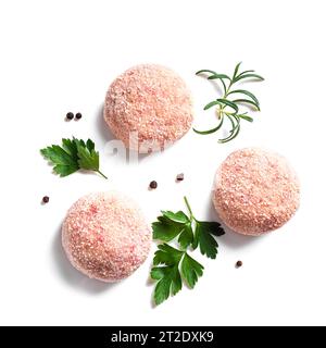 Raw cutlets or meatballs, parsley leaves, rosemary and peppercorns isolated on white background, close up. Chicken meat cutlet. Stock Photo