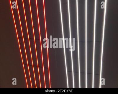 Blurred, no focused, abstract festive vertical background with red, orange and white neon led stripes on a black background, photography for creative Stock Photo