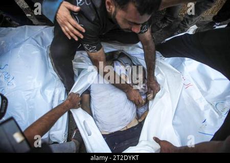 People wait to carry out dead bodies of Palestinians, who lost their lives during the attacks of Israel, from the Shifa Hospital, and to perform funeral prayer for them as Israeli airstrikes continue on the 6th day in Gaza City. Palestine. Stock Photo