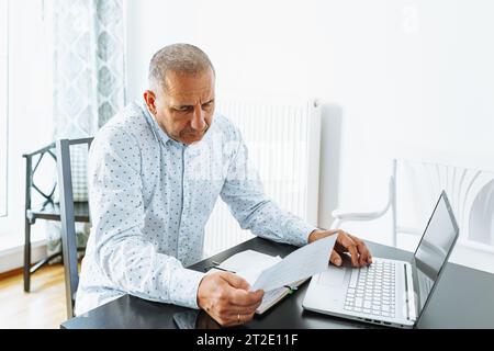 middle-aged man writes notes in notebook Stock Photo
