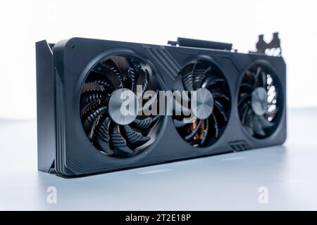 a modern powerful gaming graphics card for a computer with three fans. the concept of PC hardware. Gaming video card Stock Photo