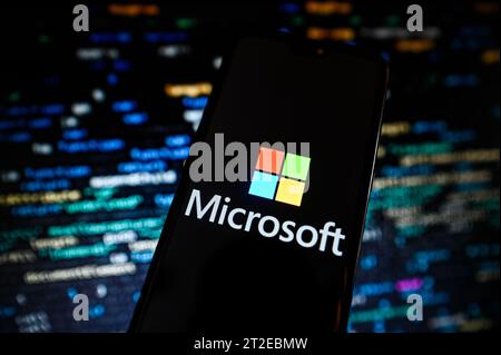 Poland. 18th Oct, 2023. In this photo illustration a Microsoft logo is displayed on a smartphone with programing codes on the background.economy, business, logo, logos, sign, brand, technology, online, smartphone, cellphone, mobile phone, phone, device Credit: SOPA Images Limited/Alamy Live News Stock Photo