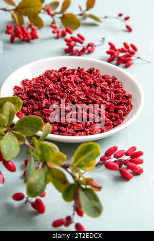 Pile of dried Berberis vulgaris also known as common barberry, European barberry or barberry on plate in home kitchen. Edible herbal medicinal. Stock Photo