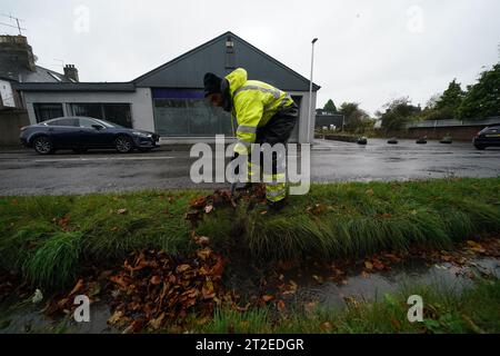 A workman clears a drainage ditch in the village of Edzell, Scotland, ahead of Storm Babet. The UK is bracing for heavy wind and rain from Storm Babet, the second named storm of the season. A rare red weather warning stating there is a 'risk to life' has been issued for parts of Scotland as the storm is expected to batter the UK on Thursday. Picture date: Thursday October 19, 2023. Stock Photo