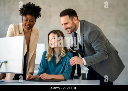 Group of multiethnic business people analyzing data using computer while working in the office Stock Photo