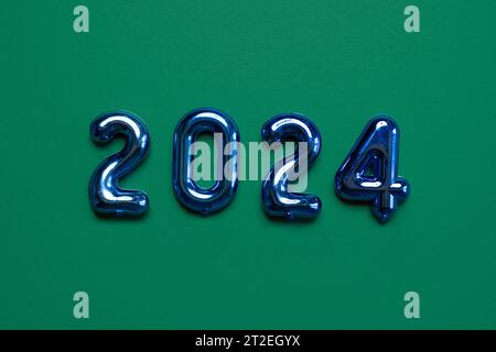 New Year Green Background. Blue Shiny Decoration. Christmas Greeting Card Mockup. Sparkle Baubles. Top view, Copy Space. Balls, Confetti on Dark Green Stock Photo