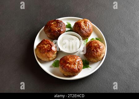 Cutlets from minced meat with sauce on plate over dark background. Close up view Stock Photo