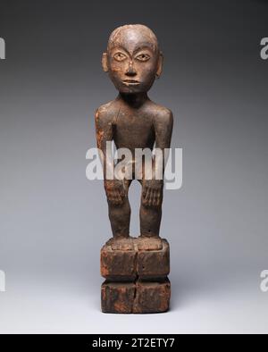 Figure of a Male Rice Deity (Bulul) Ifugao people 19th century or earlier This standing male figure representing a rice deity (bulul) from the Ifugao people of northern Luzon Island in the Philippines is an outstanding and highly important expression of the foremost tradition of anthropomorphic sculpture in the northern Philippines. Sculpted with exceptional elegance and sensitivity for its genre, it is among the finest expressions of its type. While bulul figures are fairly common, the great majority are of more recent date and are more roughly carved than this work. The figure stands on a sq Stock Photo