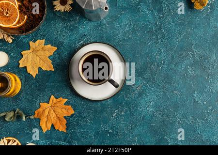 autumn leaves and cup of black coffee near spices and honey on blue textured surface, thanksgiving Stock Photo