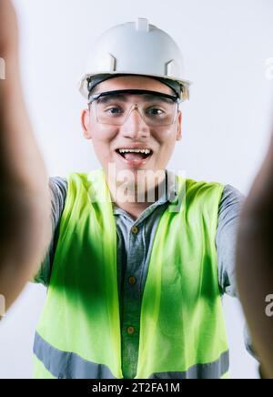 Cheerful builder engineer taking a selfie isolated. Engineer taking a selfie isolated. Smiling male engineer taking a selfie looking at camera Stock Photo