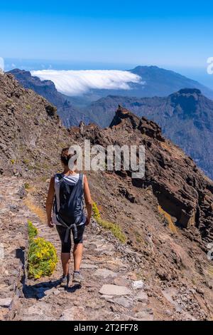 A young woman walking along the path of the Roque de los Muchachos at the top of the Caldera de Taburiente, La Palma, Canary Islands. Spain Stock Photo