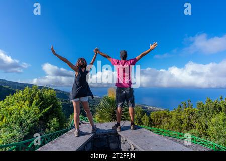 A very happy couple on top of the mountain at the viewpoint of the Cubo de la Galga natural park on the northeast coast on the island of La Palma Stock Photo