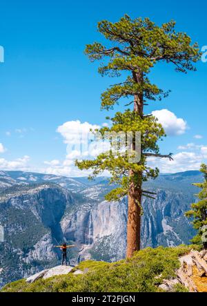 A young woman in Sentinel Dome looking at Upper Yosemite Fall in ...