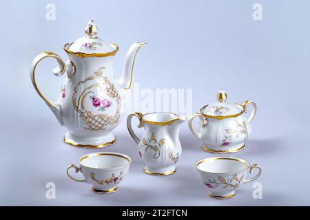 A set of antique tea (coffee) utensils with empty cups on a gray background. Stock Photo