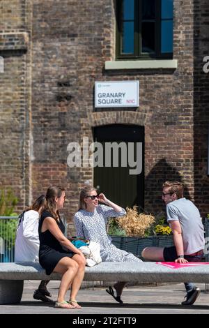 Group of young professionals enjoying the sun on a lunch break in Granary Square, Kings Cross, London on a sunny day Stock Photo