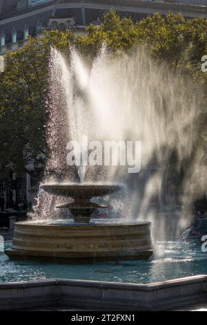 One of the fountains in Trafalgar Square, London, on a windy autumn day Stock Photo