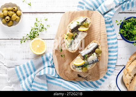 Sardines sandwiches on a white wooden background. Mediterranean food. Top view Stock Photo