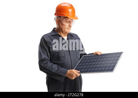 Factory worker in a uniform wearing helmet and goggles and looking at a solar panel isolated on white background Stock Photo