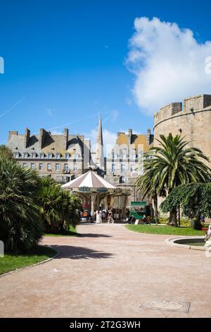 SAINT MALO, FRANCE - AUGUST 2023 - palms and vintage carousel at the entrance of the Old Town. Brittany, France. Vertical shot. Stock Photo