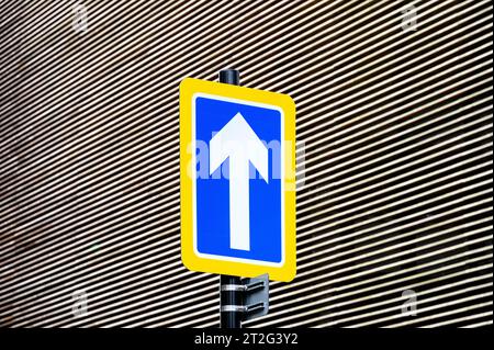 White arrow pointing upwards on a blue and yellow background, UK Stock Photo