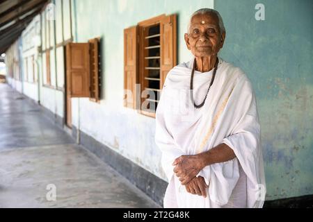 The oldest Hindu monk in traditional clothes at the Uttar Kamalabari Hindu monastery, Majuli Island, Assam, India Stock Photo