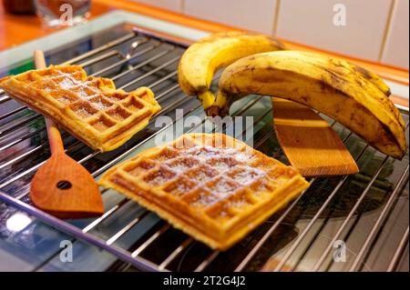 Ready-made waffles that lie on a grating to cool and bananas as an ingredient. Stock Photo