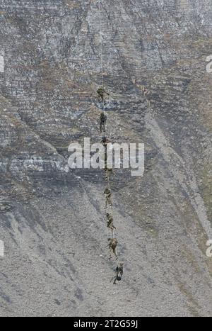 Kommandosoldaten des Schweizer Kommando Spezialkräfte KSK werden auf der Axalp nach ihrem Einsatz von einem Helikopter AS-332 Super Puma an einem Seil hängend aufgenommen und zügig verbracht. Flugvorführungen der Schweizer Luftwaffe auf dem Fliegerschiessplatz Axalp-Ebenfluh am 18. Oktober 2023. Axalp ob Brienz Kanton Bern Schweiz *** Commandos of the Swiss Special Forces Command KSK are picked up by a helicopter AS 332 Super Puma hanging on a rope on the Axalp after their mission and quickly taken away. Flight demonstrations of the Swiss Air Force on the air force firing range Axalp Ebenfluh Stock Photo