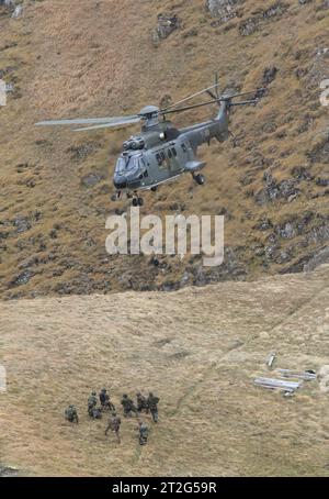 Kommandosoldaten des Schweizer Kommando Spezialkräfte KSK werden auf der Axalp nach ihrem Einsatz von einem Helikopter AS-332 Super Puma an einem Seil hängend aufgenommen und zügig verbracht. Flugvorführungen der Schweizer Luftwaffe auf dem Fliegerschiessplatz Axalp-Ebenfluh am 18. Oktober 2023. Axalp ob Brienz Kanton Bern Schweiz *** Commandos of the Swiss Special Forces Command KSK are picked up by a helicopter AS 332 Super Puma hanging on a rope on the Axalp after their mission and quickly taken away. Flight demonstrations of the Swiss Air Force on the air force firing range Axalp Ebenfluh Stock Photo