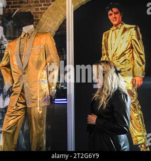 London, UK. 19th Oct, 2023. A visitor looks at the custom made Gold Lame Suit, made for 'golden boy' Elvis. Worn on the cover of '50,000,000 Elvis Fans Can't Be Wrong - Elvis' Gold Records Volume 2'. The 'Direct from Graceland: Elvis' exhibition features over 400 artefacts and iconic belongings owned by Elvis, direct from the icon's Graceland home in Memphis, Tennessee. The exhibition opens on Oct 20 at the Arches London Bridge venue in Bermondsey Street. Credit: Imageplotter/Alamy Live News Stock Photo