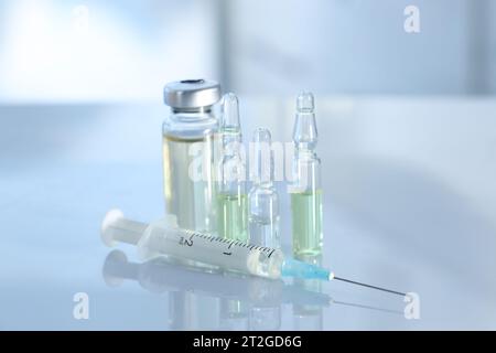 Glass vial, ampoules and syringe on white table, closeup Stock Photo