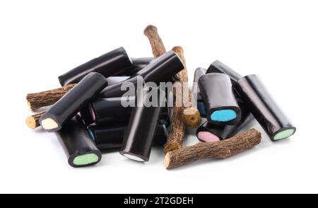 Many tasty candies and dried sticks of liquorice root isolated on white Stock Photo