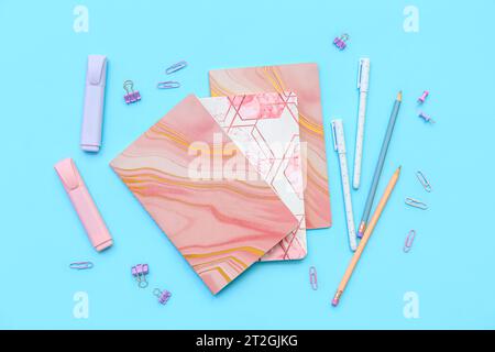 Composition with notebooks and different stationery on color background Stock Photo