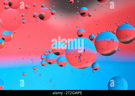Macro photography with circles oil droplets water surface. Abstract with blue, black and red background with oil bubbles Stock Photo