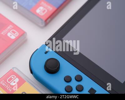 Tambov, Russian Federation - October 15, 2023 A Nintendo Switch video game console with a blue joy-con and boxes with games next to it. Close up. Stock Photo