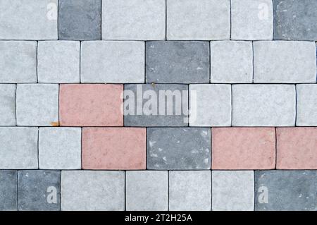 Texture of gray rectangular concrete stone paving slabs on the road with seams. The background. Stock Photo