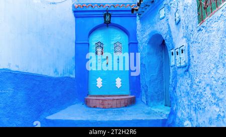Blue door in Chefchaouen town in Morocco, known as the Blue Pearl, famous for its striking blue color painted medina buildings and streets, creating a Stock Photo