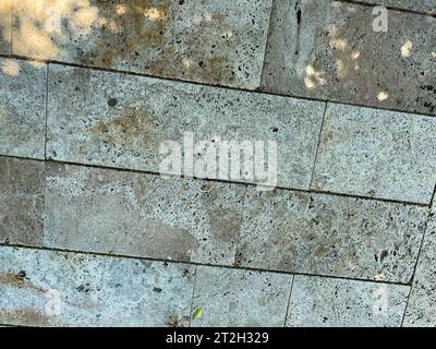 The pedestrian walkway is paved with modern concrete paving slabs of rectangular shape but of different sizes. Symmetrical decreasing perspective. Stock Photo