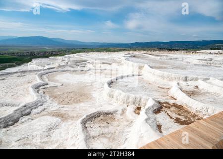 White terraces (natural travertine formations and hot pools) in Pamukkale, Turkey. The terraces are made of travertine, a sedimentary rock deposited b Stock Photo
