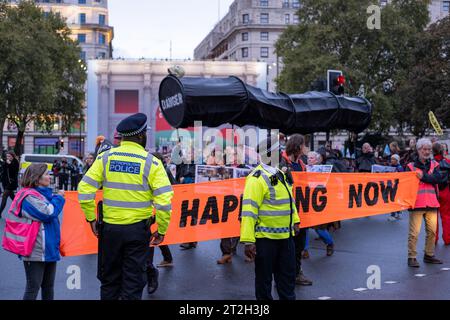 Police monitor Fossil Free London protesters as they block road with protest banner at Marble Arch in Central London. October 2023. Stock Photo