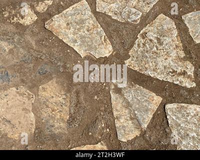 The texture of the wall is made of beautiful smooth, natural old, old, shuffled gray densely laid out without gaps, cobblestones, masonry with uneven Stock Photo