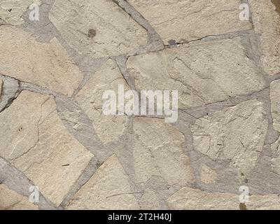 The texture of the wall is made of beautiful smooth natural old old shrewded yellow densely laid out without gaps of stones, cobblestones, masonry wit Stock Photo