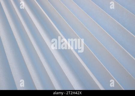 Texture of diagonal stripes with a shadow, with triangular curved ribs, edges of light white fabric, paper with triangular strips and small holes, por Stock Photo