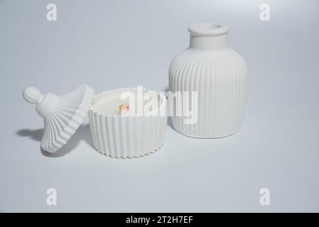 candle in white ceramic pot on a white background ,a vase with a candle.Cozy home natural eco decor Stock Photo