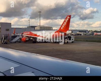 Gatwick, Surrey, England, UK.  02.09.2023.  Passenger jet parked upto  a terminal at Gatwick airport, London view from a taxing plane. Stock Photo