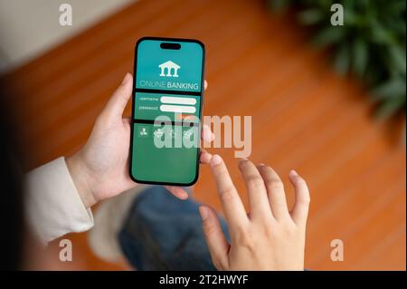 Chiang Mai, Thailand - Oct 19 2023: Close-up image of a woman logging in to her online banking account, using an online mobile banking application on Stock Photo