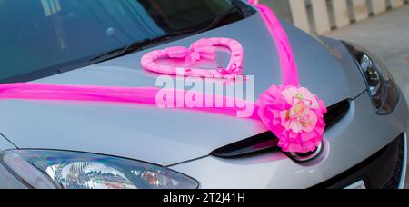 Beautiful wedding car. The front of the car is decorated with flowers. decorated with flowers for the wedding Fresh flowers on the car. Colorful weddi Stock Photo