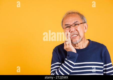 Portrait senior old man sad hand touching cheek suffering from toothache Stock Photo